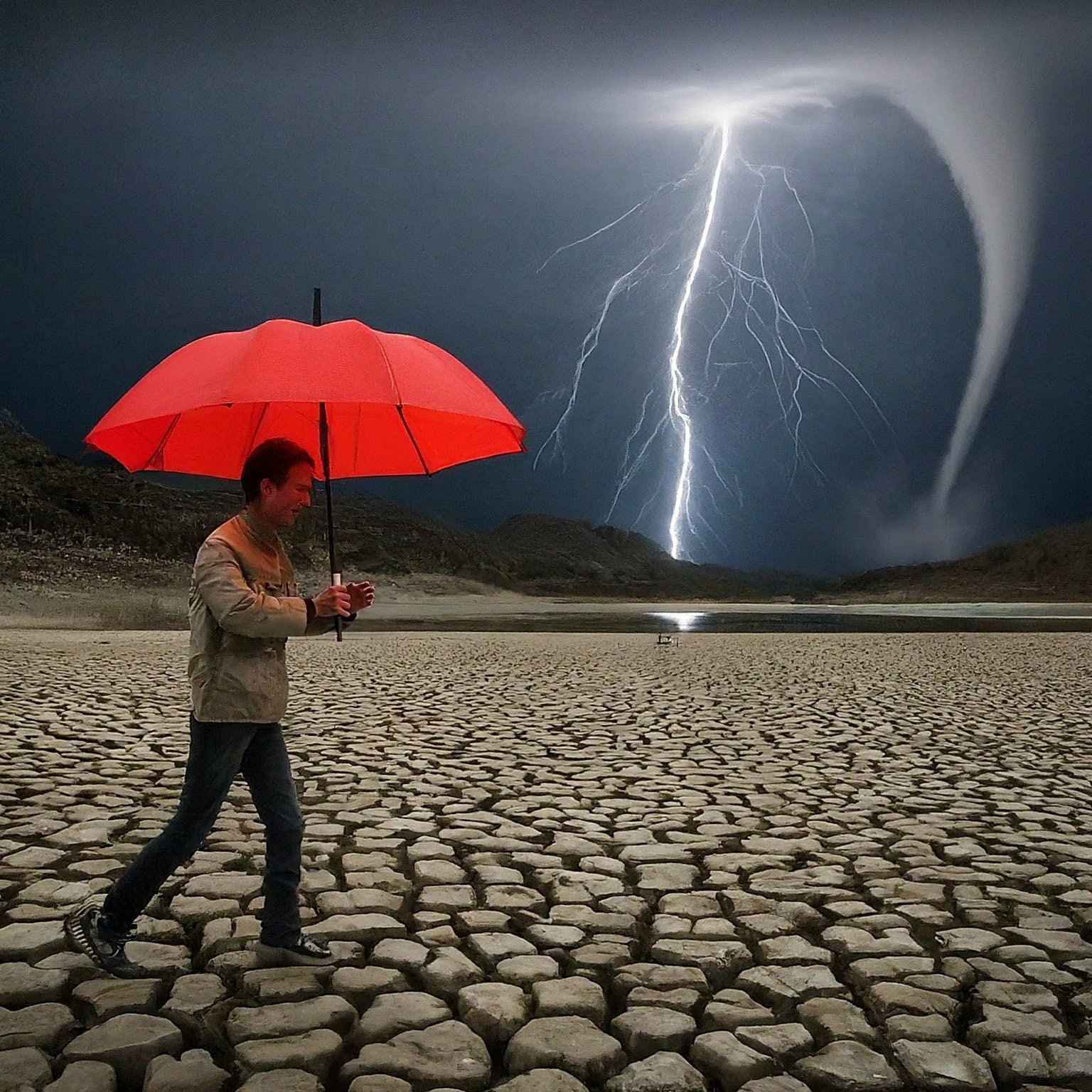 Man holding an umbrella in the desert