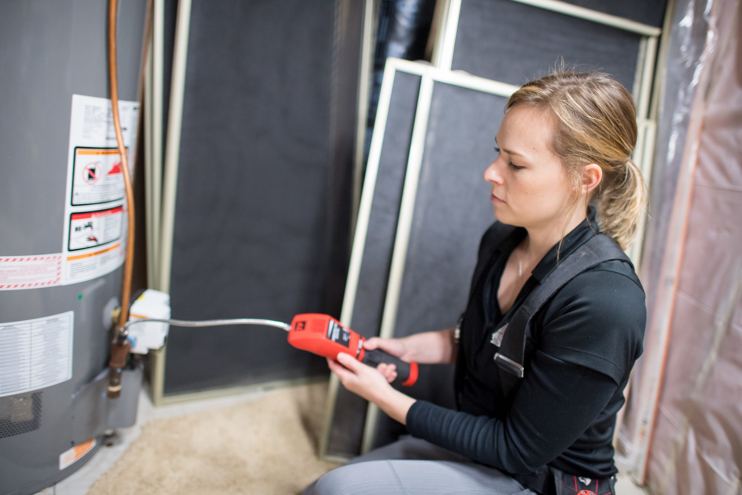 Woman inspecting a water heater